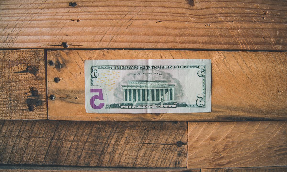 5 U.S dollar on brown wooden surface